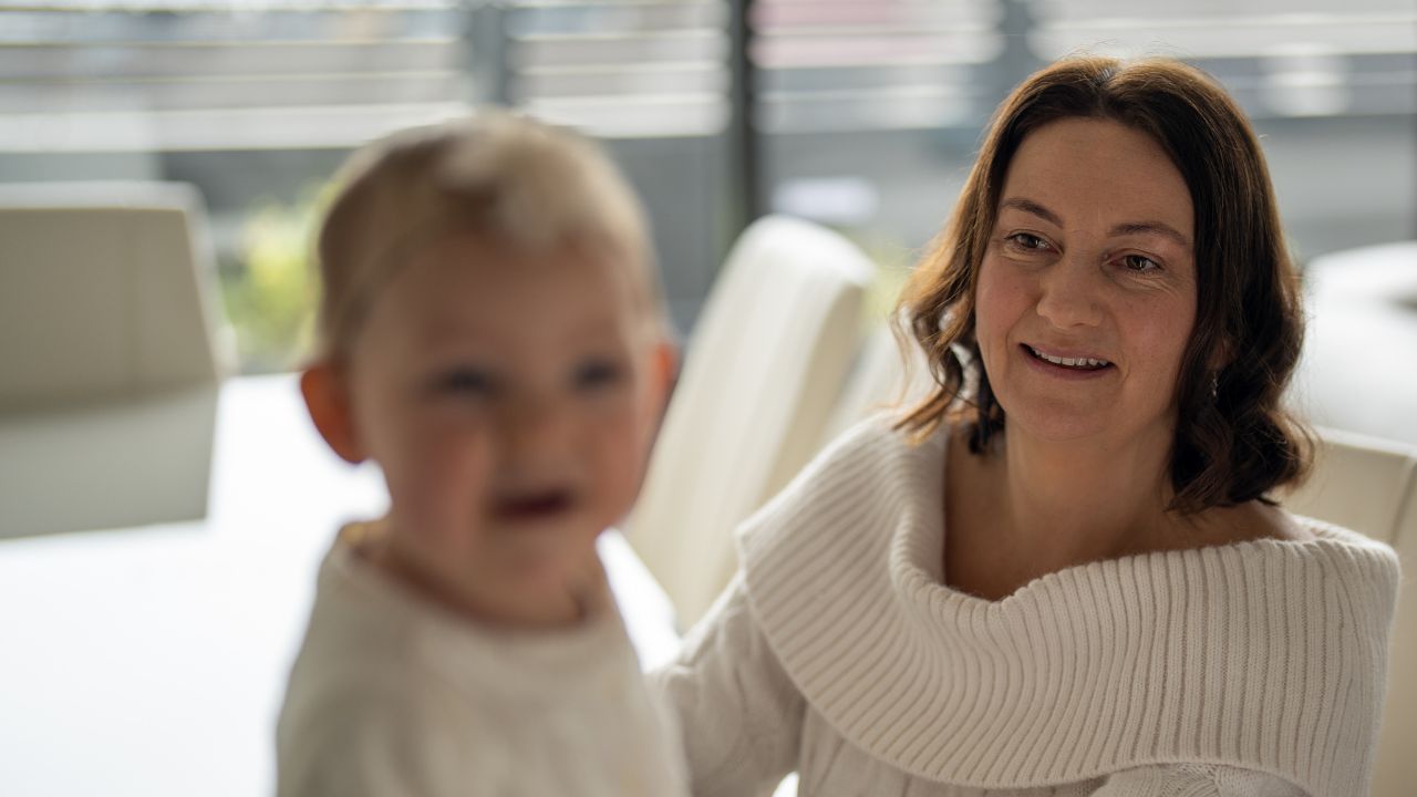 Woman sitting with a child at a kitchen table Woman sitting with a child at a kitchen table